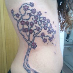 Tatuaje de árbol en el lateral del torso